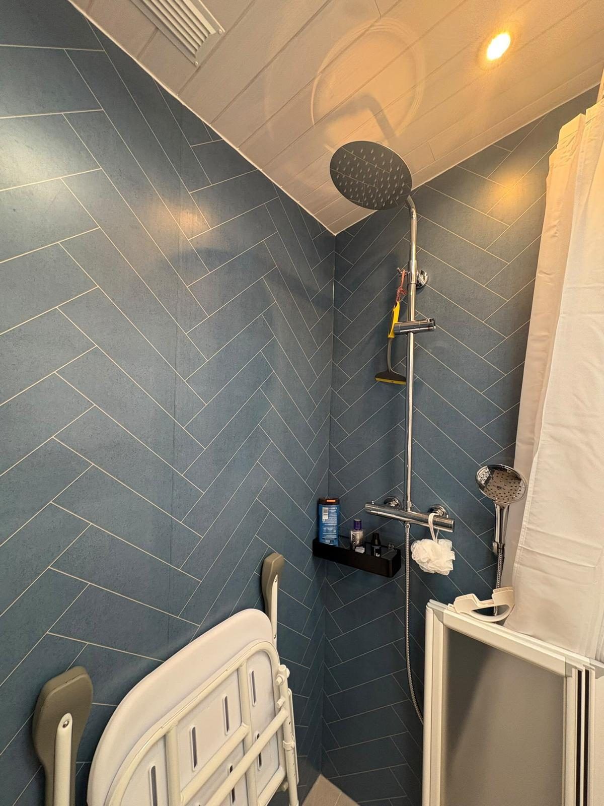 Rainfall shower and handset on blue herringbone waterproof wall boards