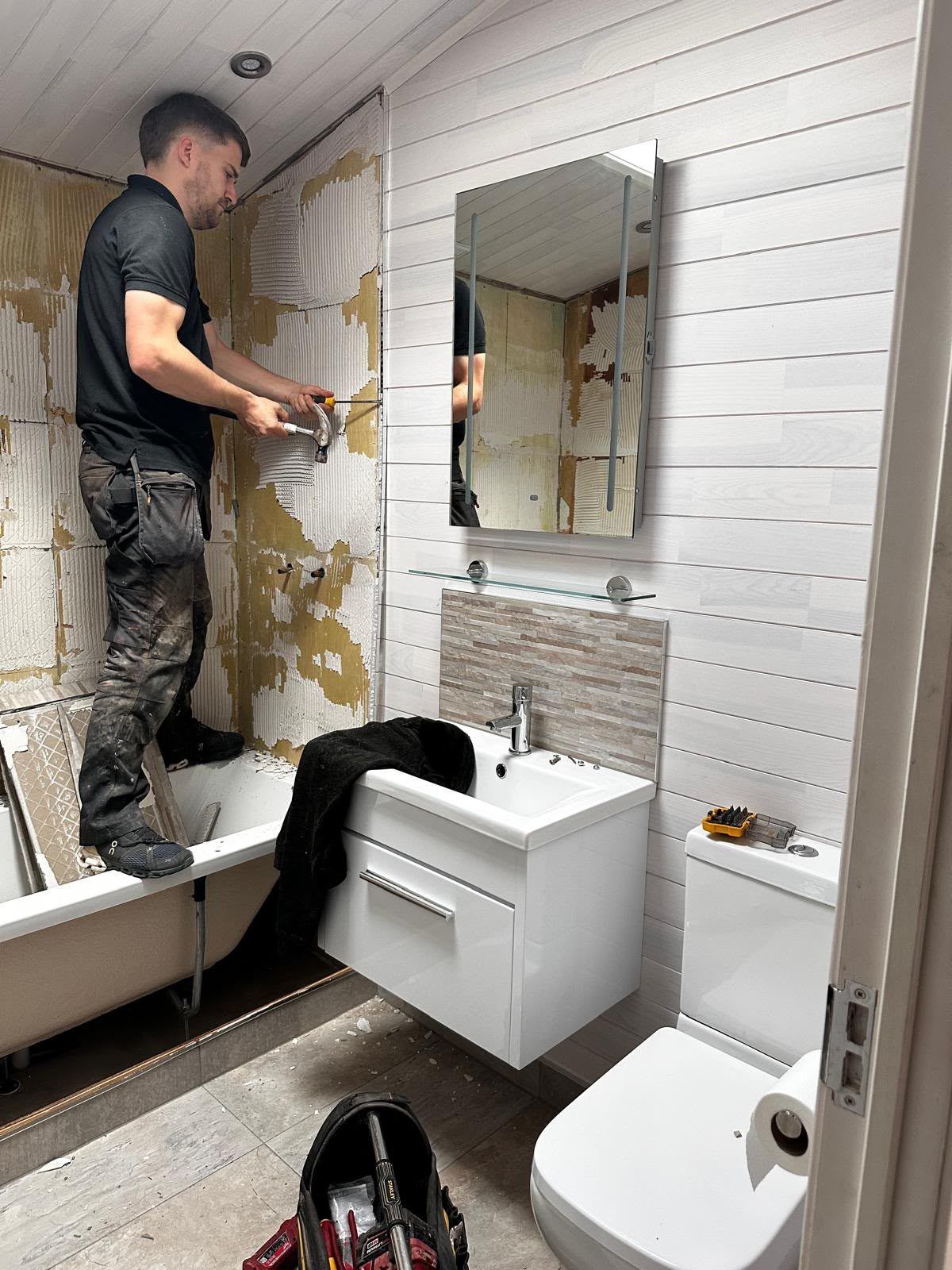 Our fitter removing the last of the old wall tiles above the bath in the Willington bathroom