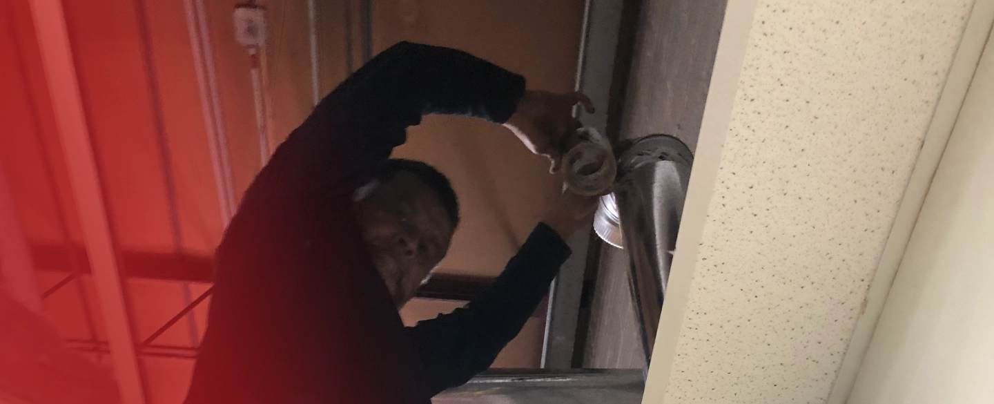 A man is opening a door with a wrench.