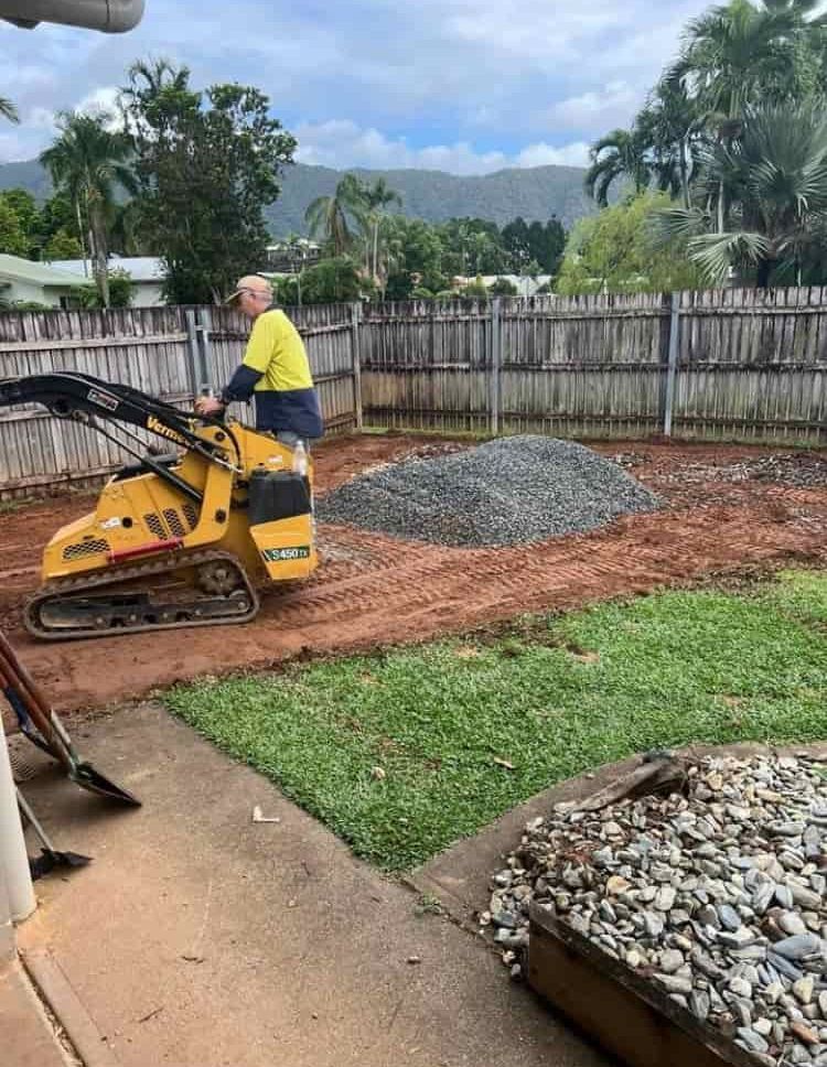 A Yellow Dump Truck is Being Loaded With Dirt by an Excavator — RCJJ Mini Loaders In Mareeba, QLD