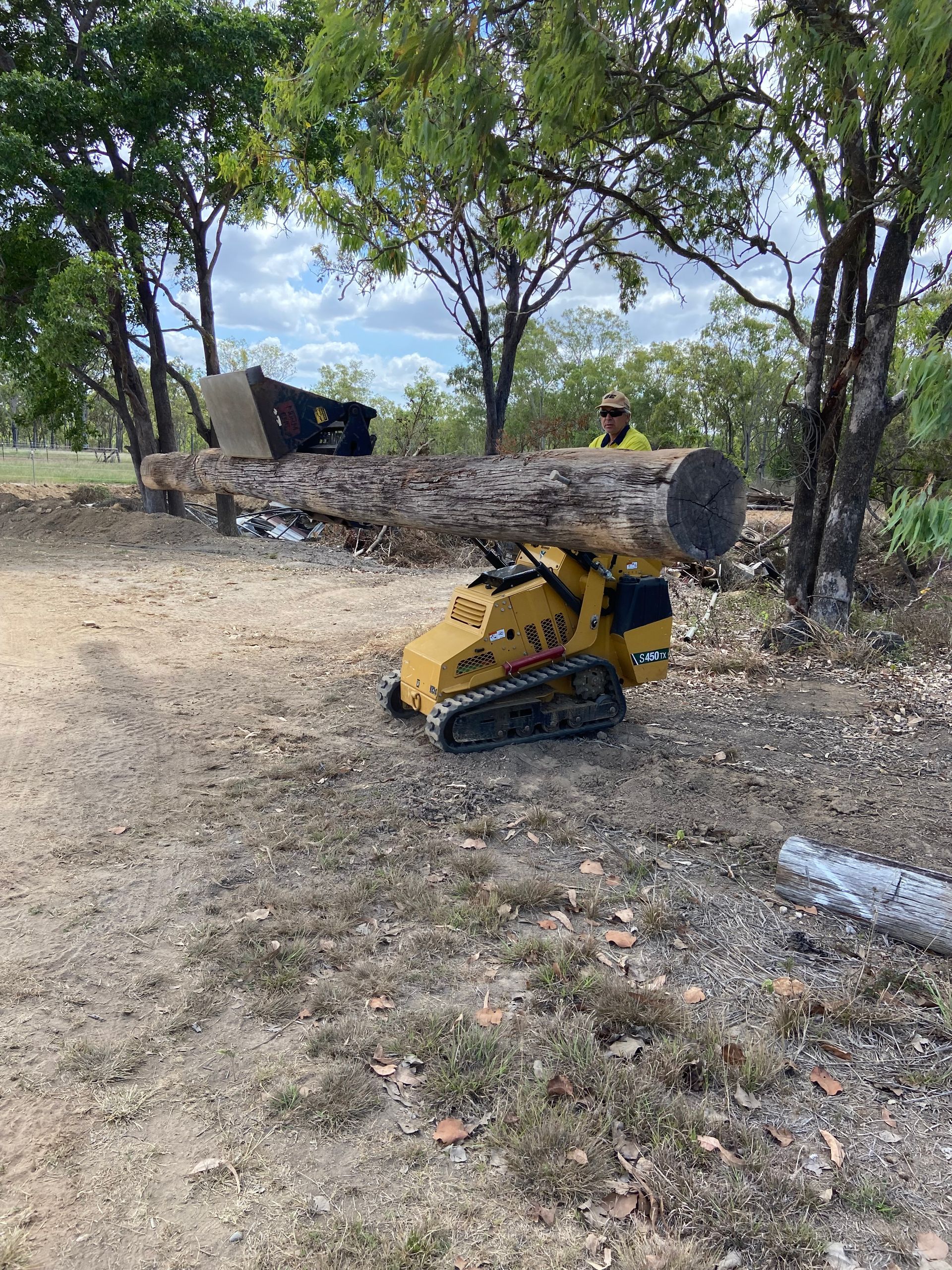 Mini Loader Loading Heavy Wood Pole — RCJJ Mini Loaders In Tablelands, QLD