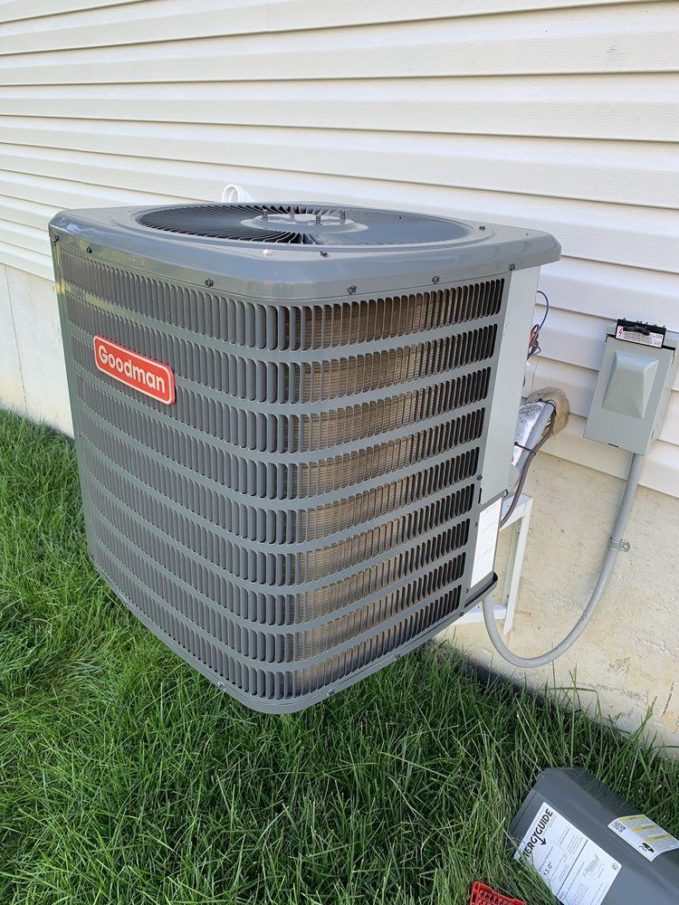 An air conditioner is sitting on the side of a house.