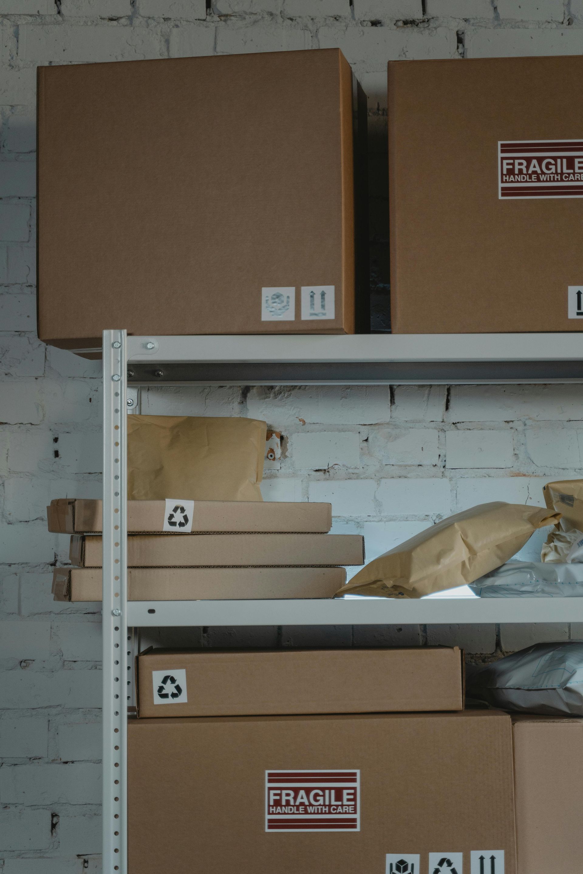 A shelf filled with cardboard boxes with fragile labels on them.