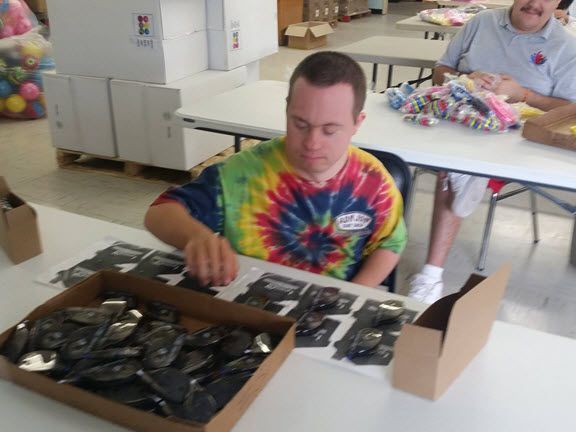 A man in a tie dye shirt is sitting at a table