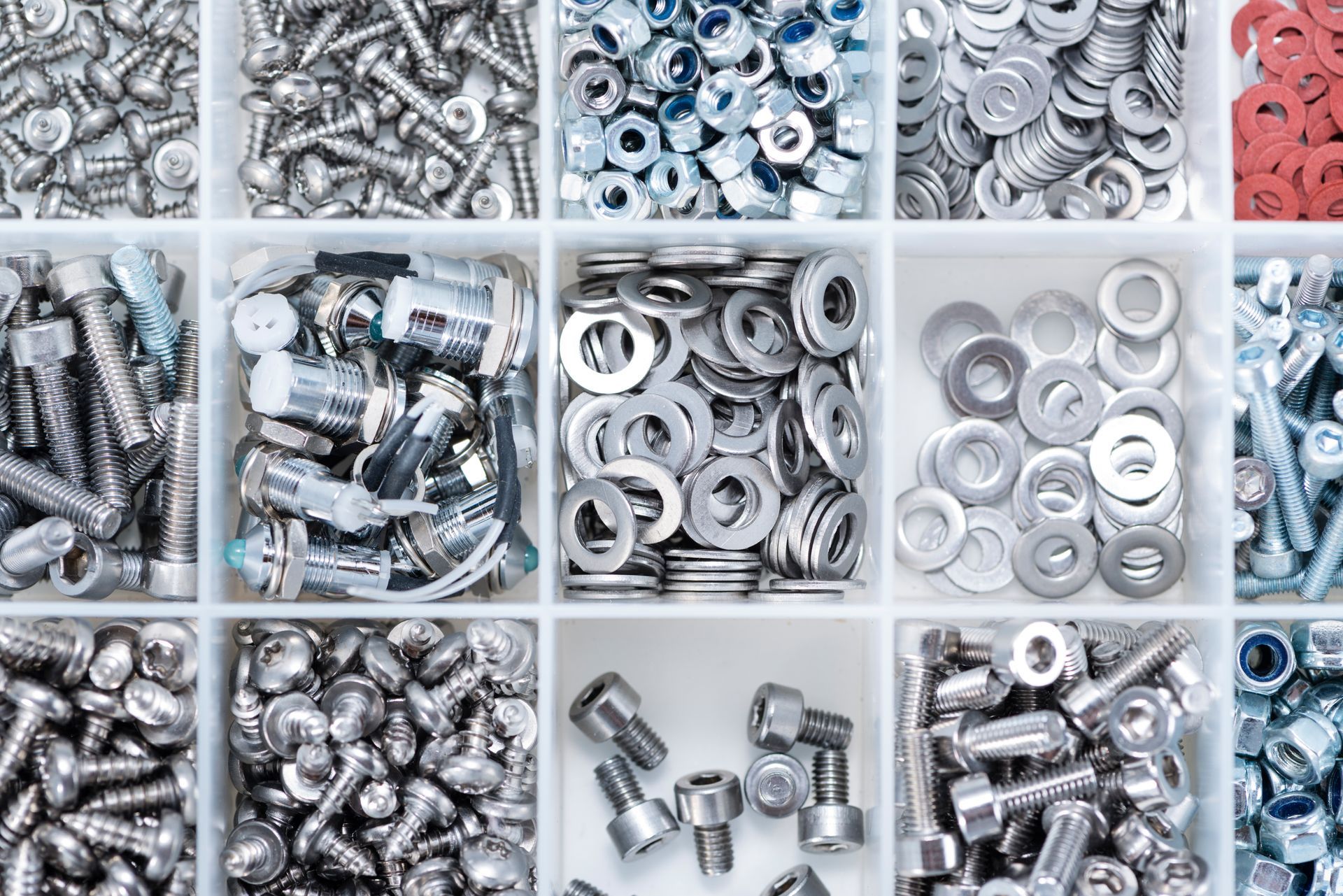 There are many different types of nuts and bolts in this box.