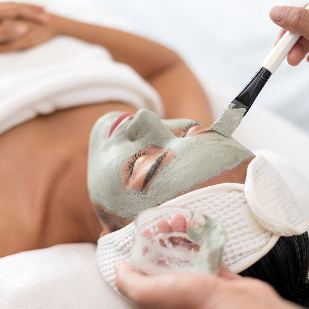 Applying Face Mask To A Woman — Great Neck, NY — Butterfly Garden Spa Applying Face Mask To A Woman — Great Neck, NY — Butterfly Garden Spa