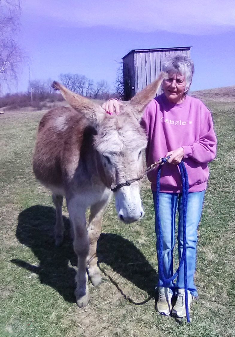 photo of Garrett riding donkey Lucky, with his new friend Valerie Toban