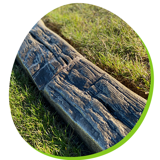 A piece of wood is sitting in the grass in a circle.