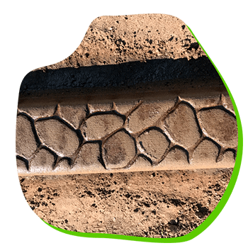 A close up of a tire on a dirt road.