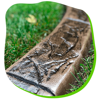 A concrete curb is sitting on top of a lush green lawn.