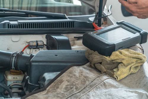 A technician using a diagnostic scan tool on a modern vehicle