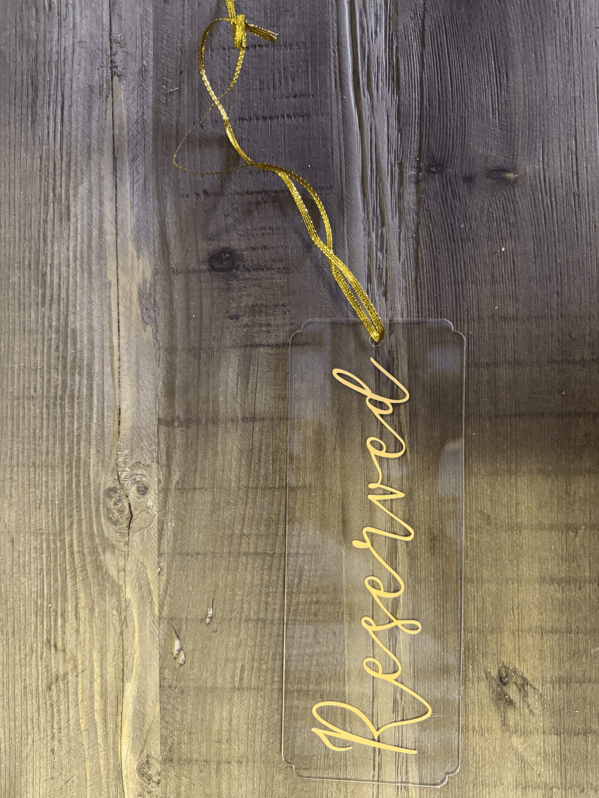 Gold cursive script on a weathered gray wood background