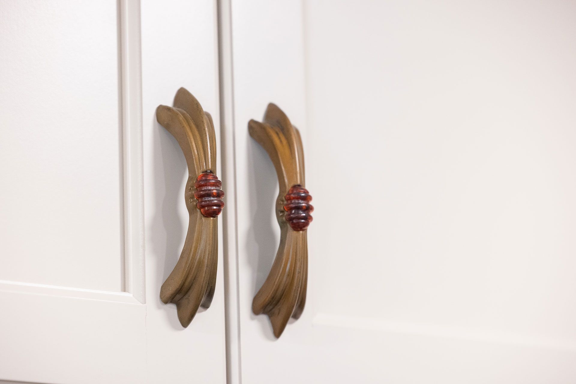 White cabinet doors with two ornate gold-colored handles.