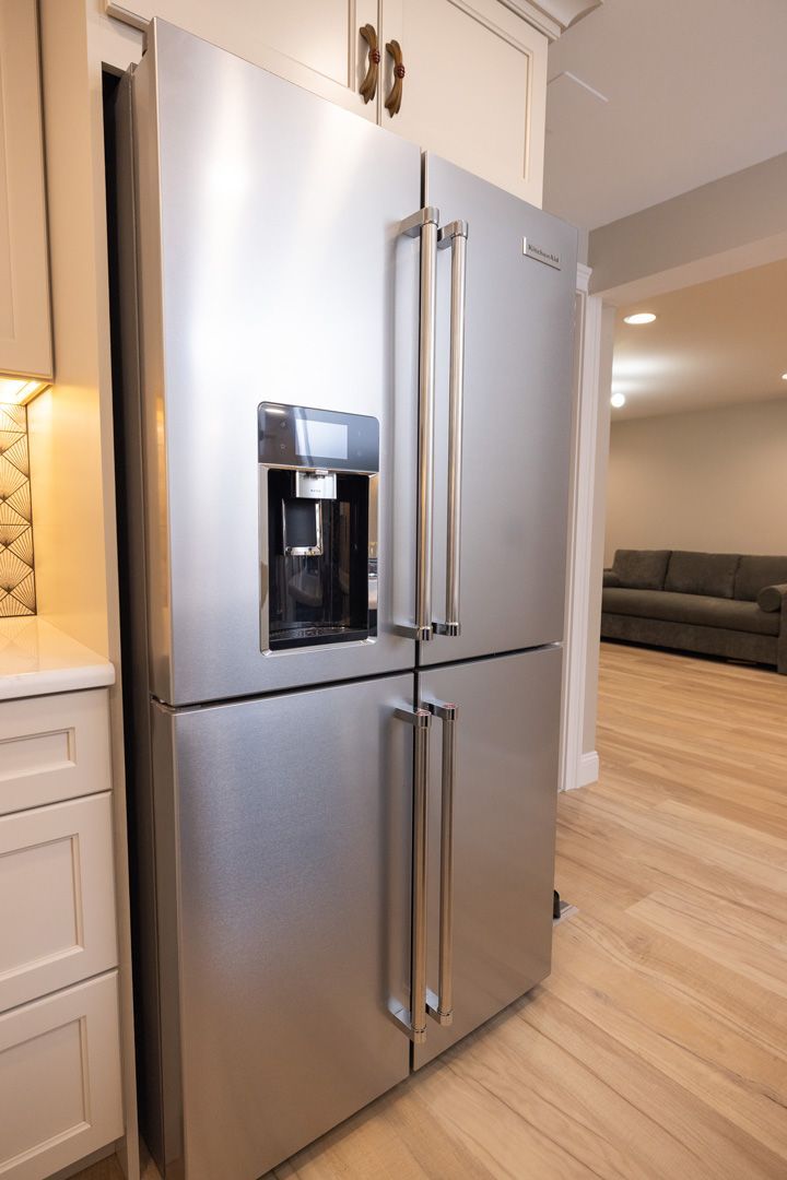 Stainless steel refrigerator with water dispenser in a kitchen.