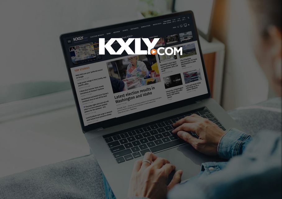 person using laptop with KXLY website on screen