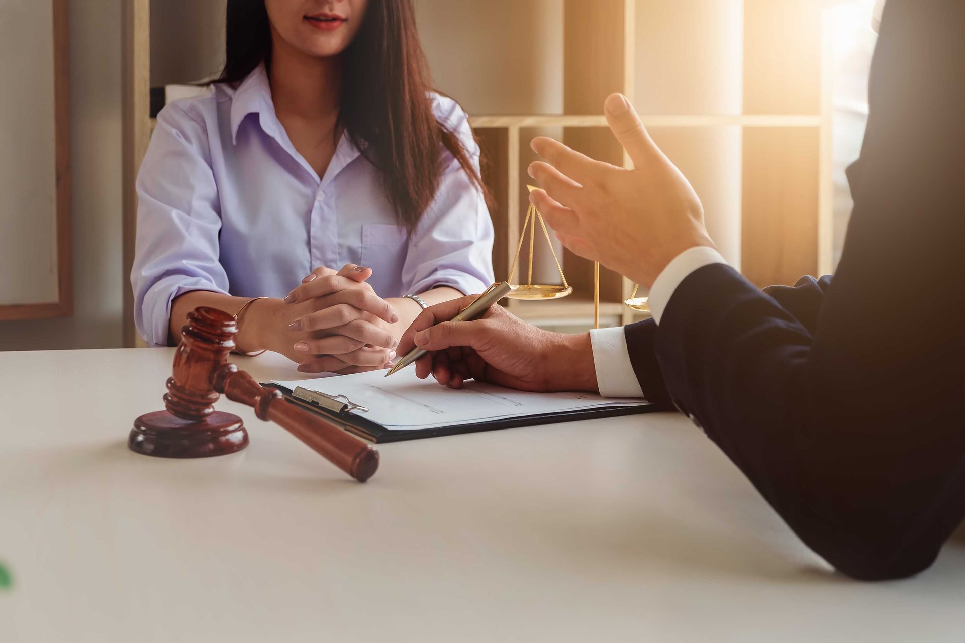 a woman sits at a table with a judge 's gavel and a clipboard