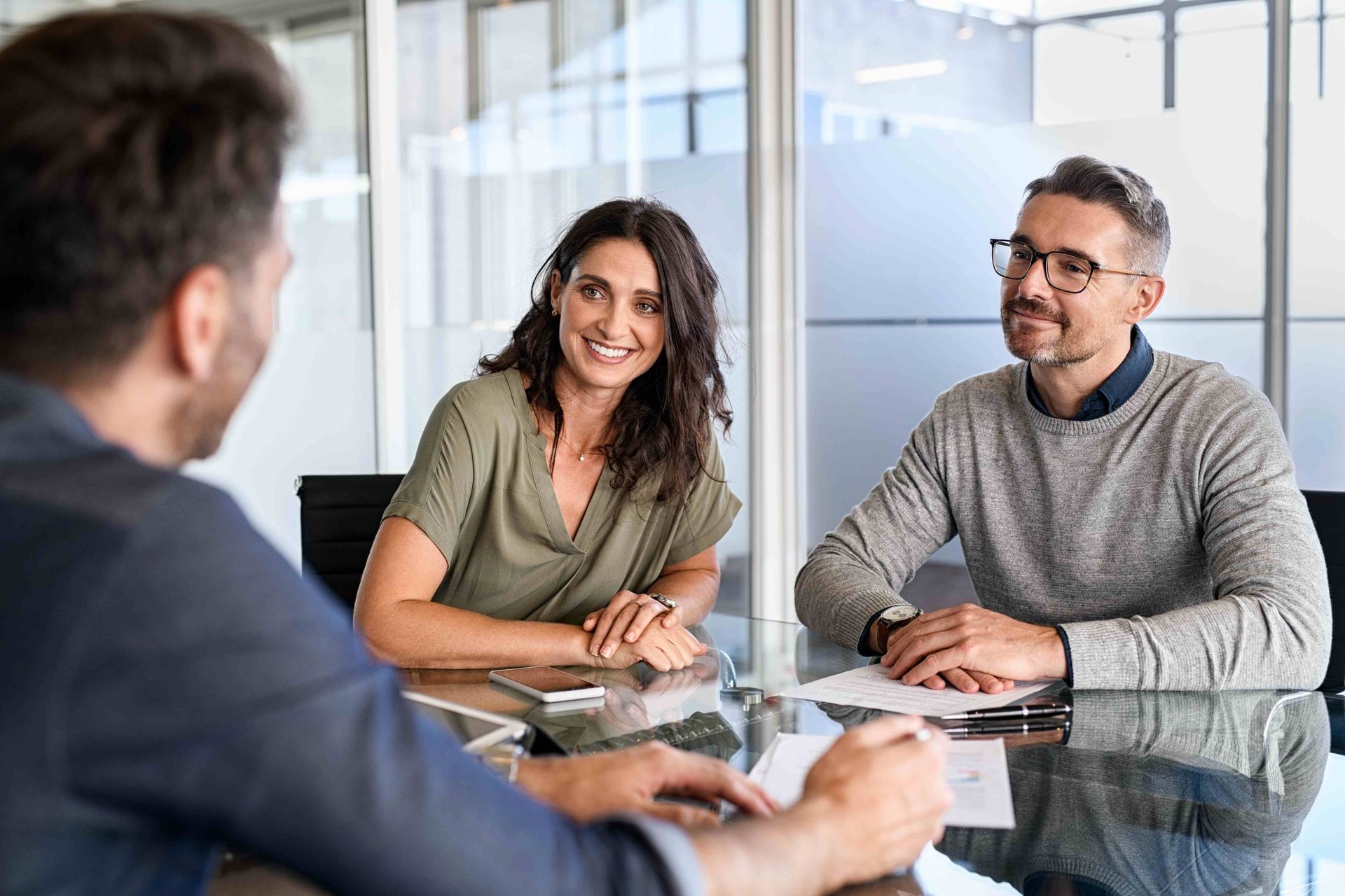 a man and a woman sit at a table with papers on it