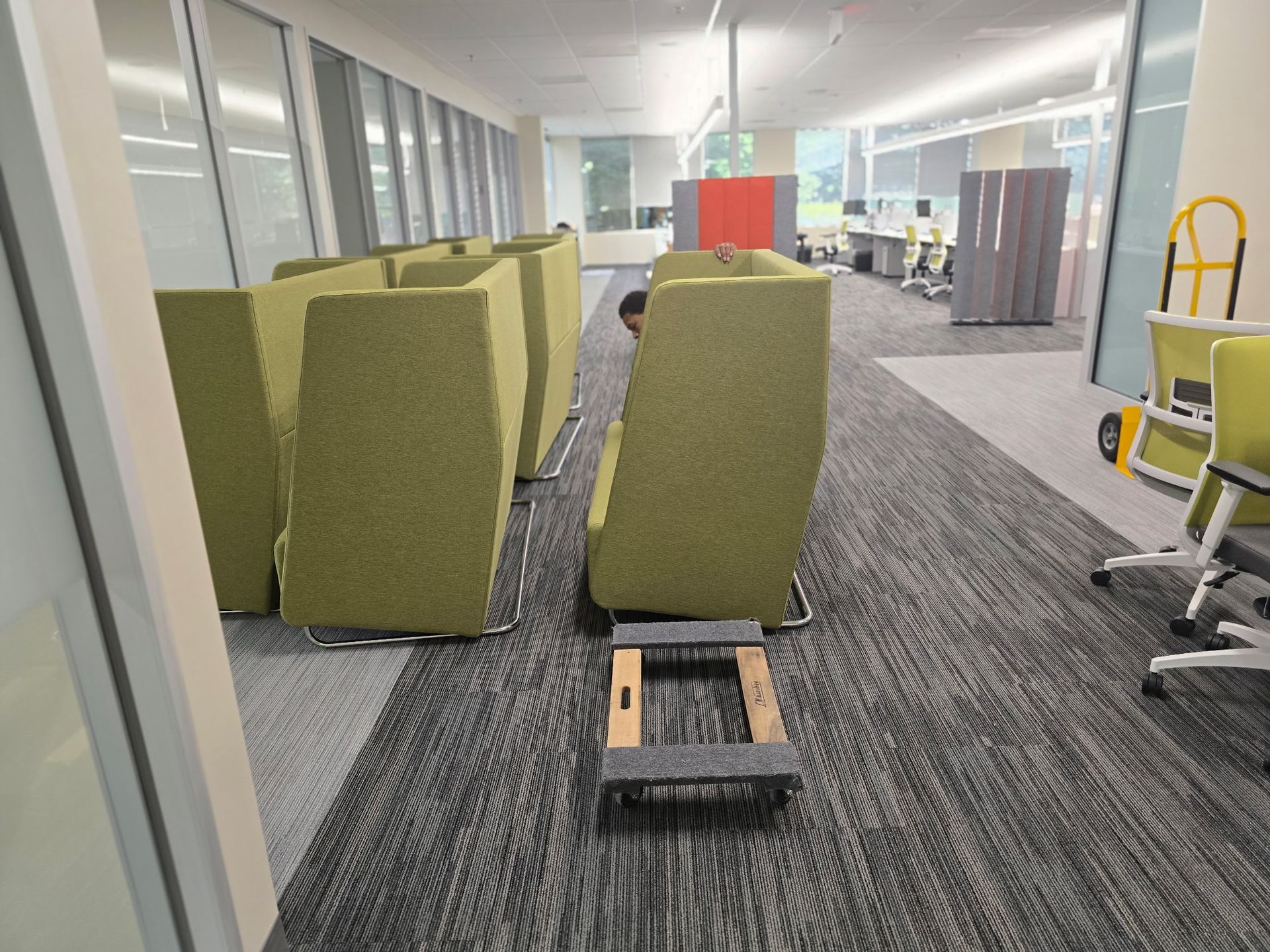An office space with large green lounging chair on dollies to be safely moved to a new office in Cary, NC.