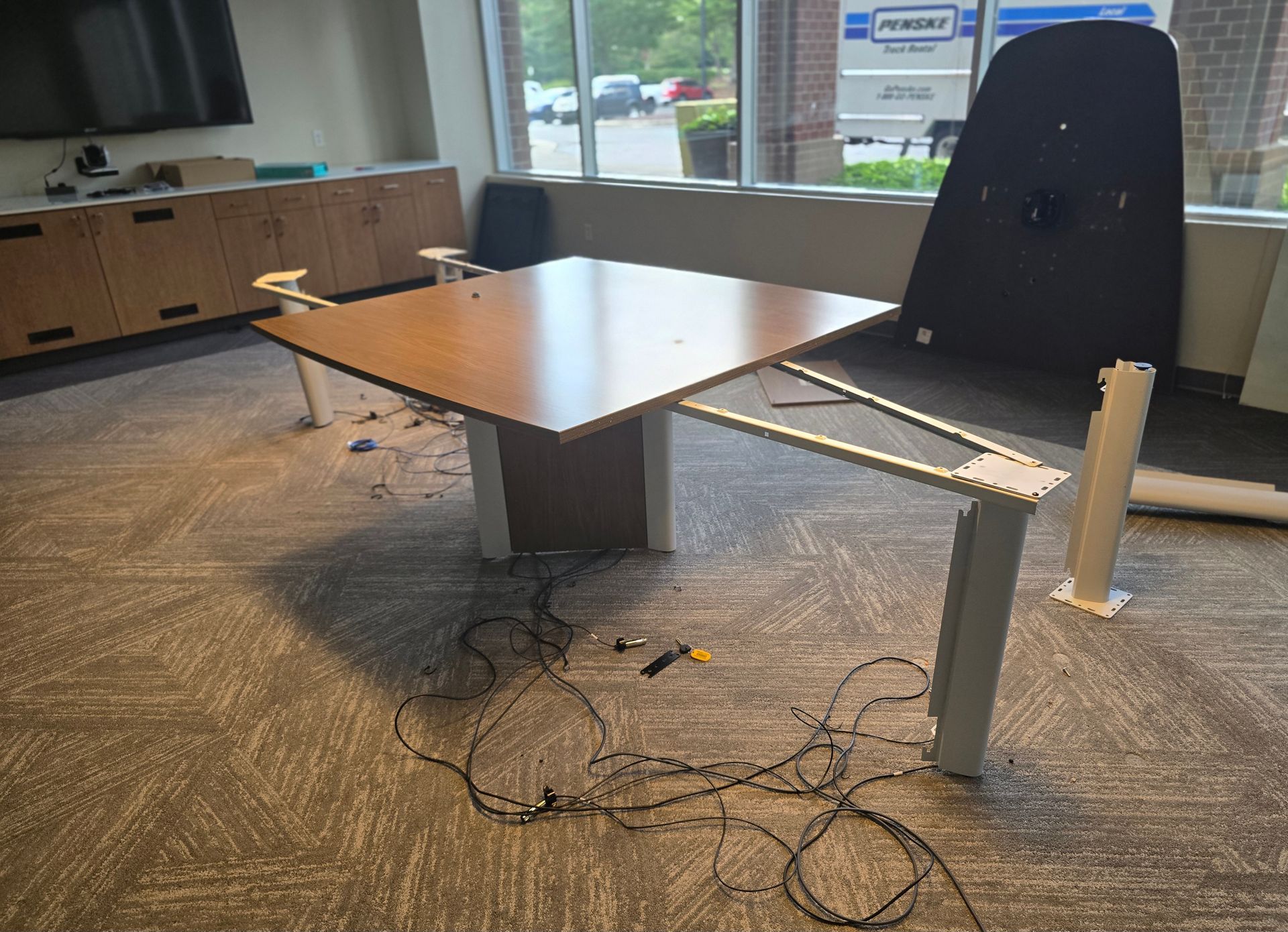 Professional commercial moving crew setting up and reassembling modular office desks in Wake County, North Carolina.