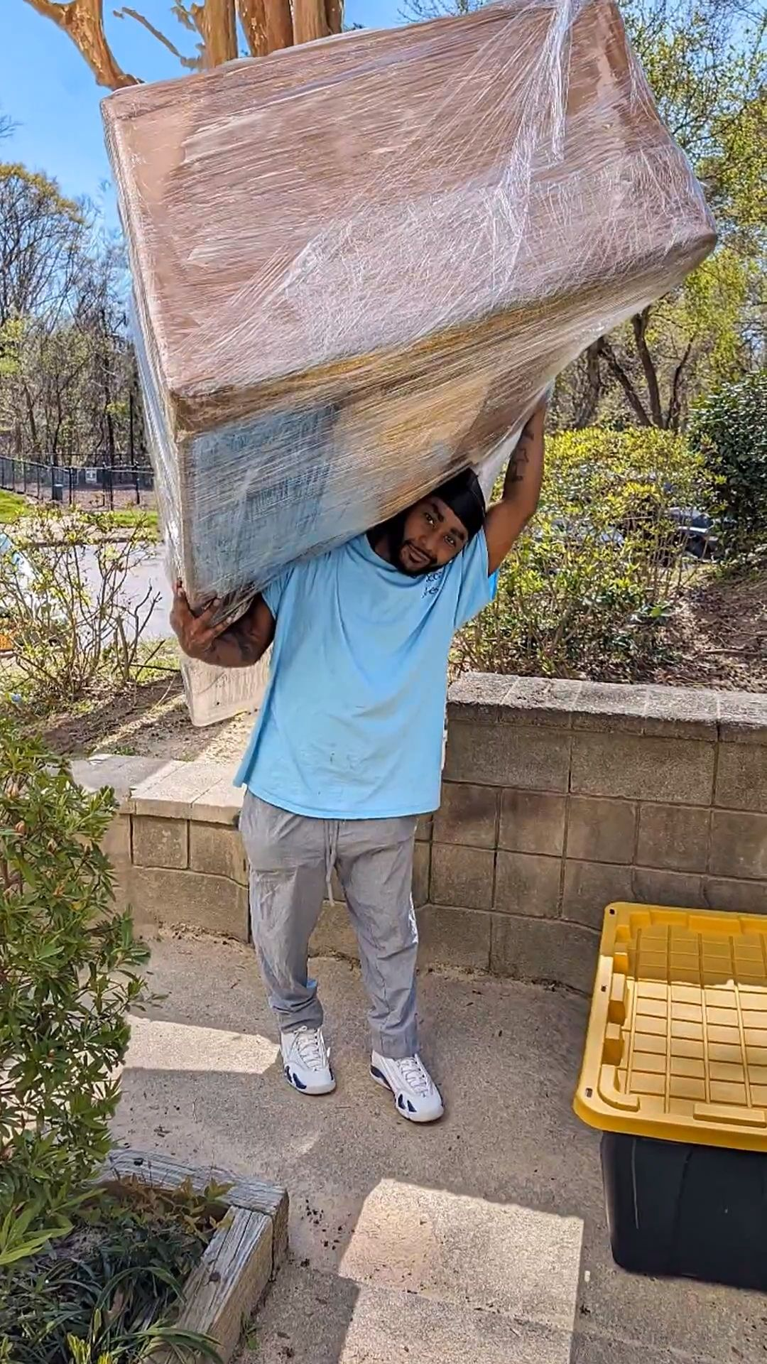 Jones Helps U Move crew member carrying a wrapped couch during a Wake County home move