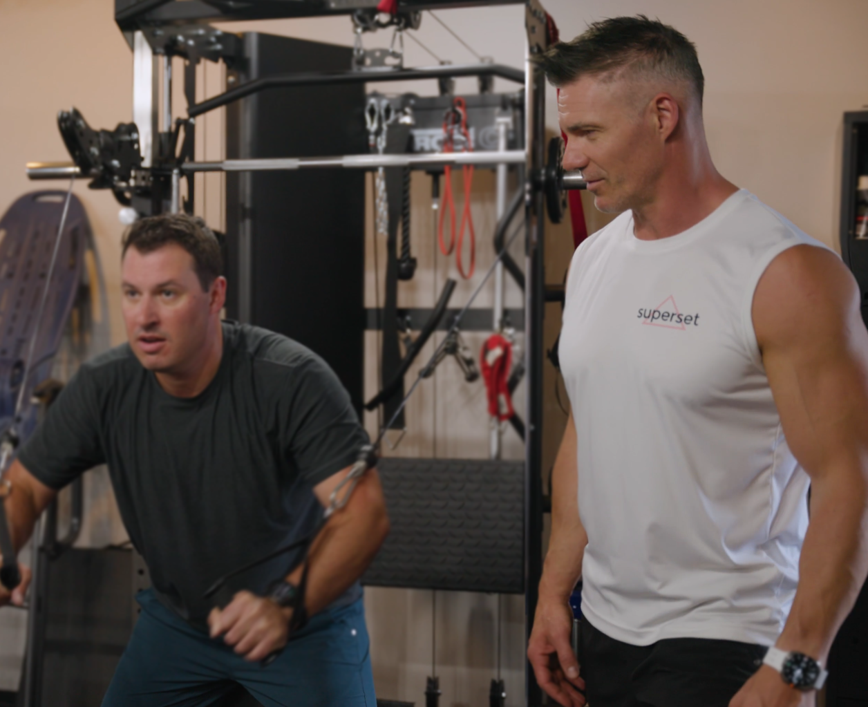 Superset Fitness owner and trainer Greg Stotz teaching a client how to use the cable machine.