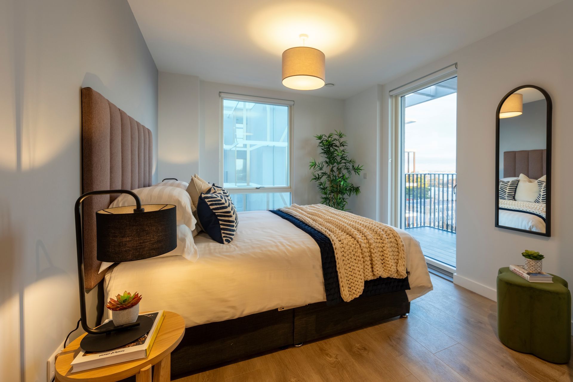 A bedroom with a large bed and a mirror.