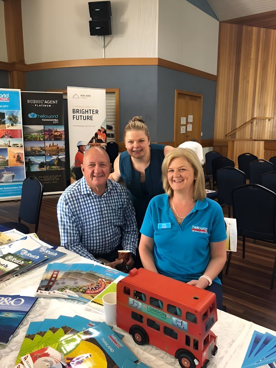 A Group Of People Are Sitting At A Table With A Toy Bus On It — Grant Finance Solutions In Toowoomba, QLD