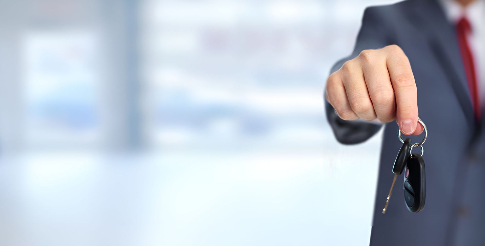 A Man In A Suit And Tie Is Holding A Car Key — Grant Finance Solutions In Warwick, QLD