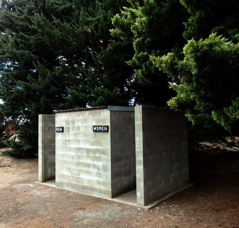 Public restroom made of gray cinder blocks,