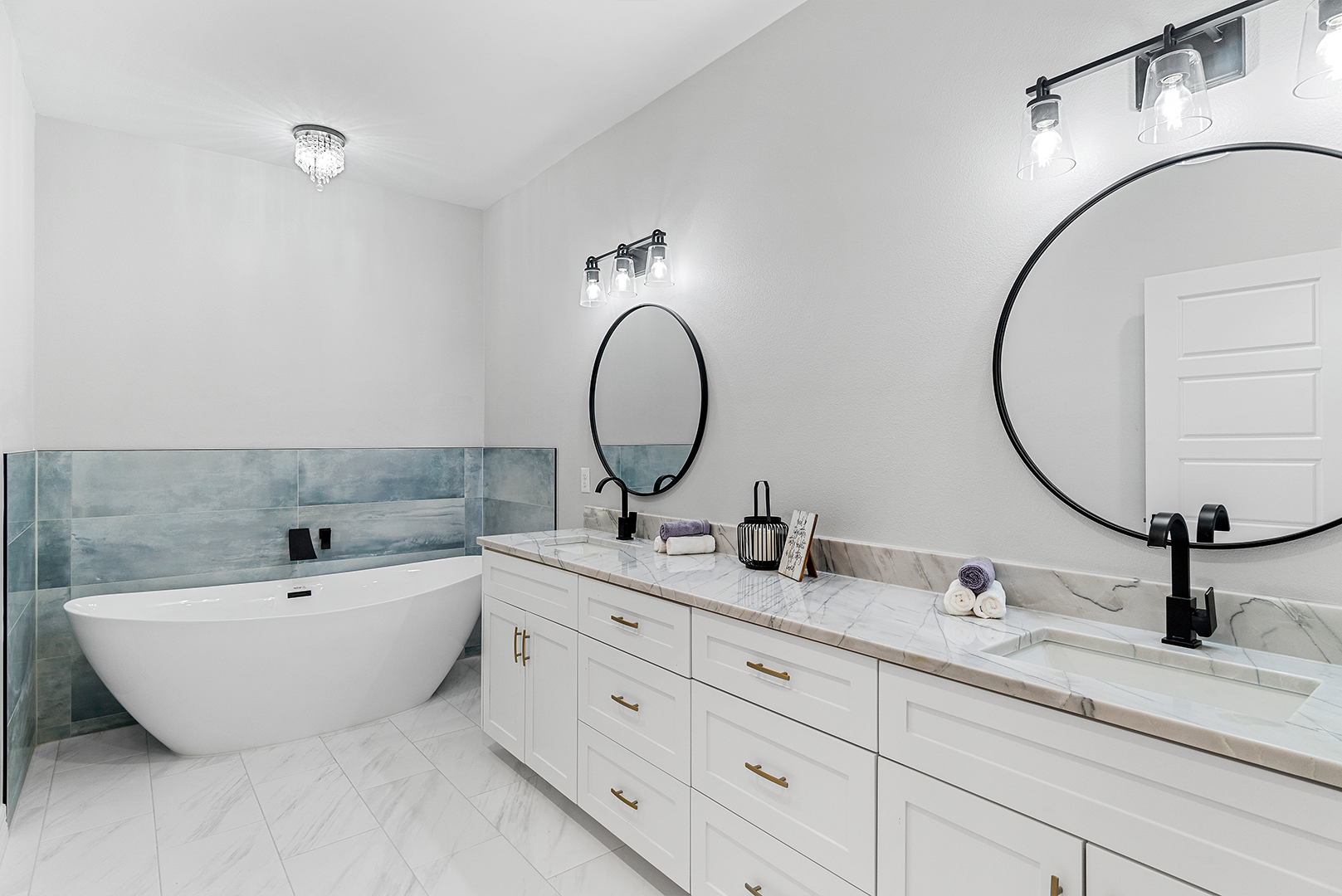 A bathroom with two sinks , a bathtub , and two mirrors.