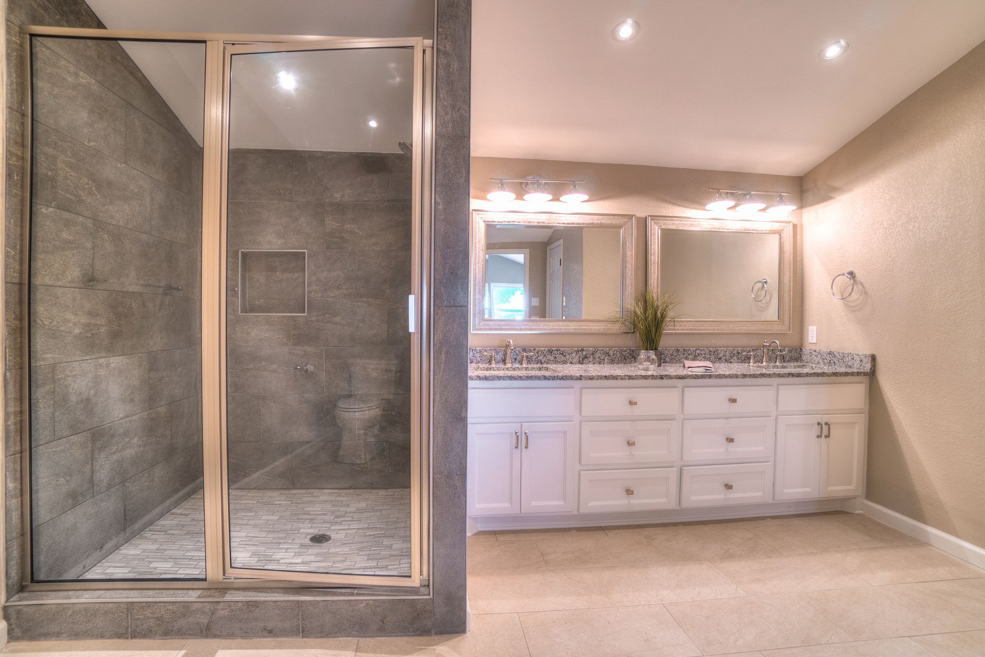 A bathroom with a walk in shower and two sinks