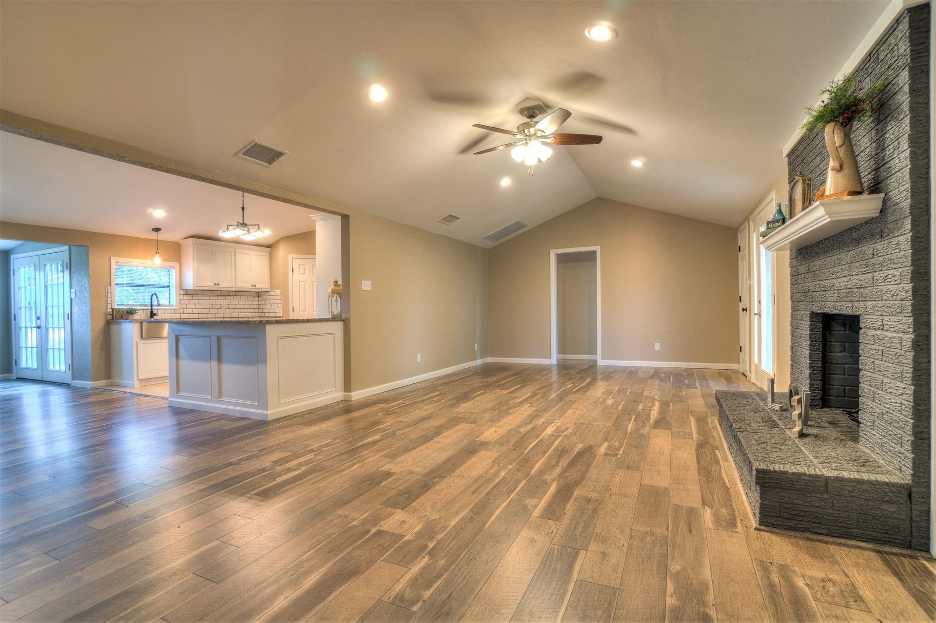 An empty living room with hardwood floors and a fireplace.