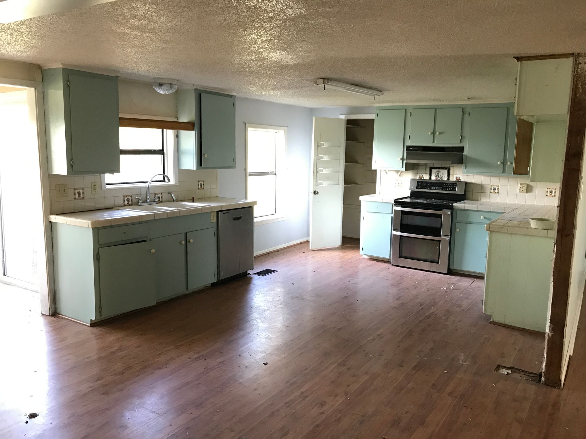 An empty kitchen with blue cabinets and a stove