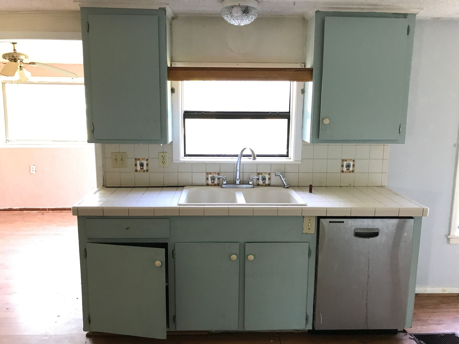 A kitchen with blue cabinets a sink and a window