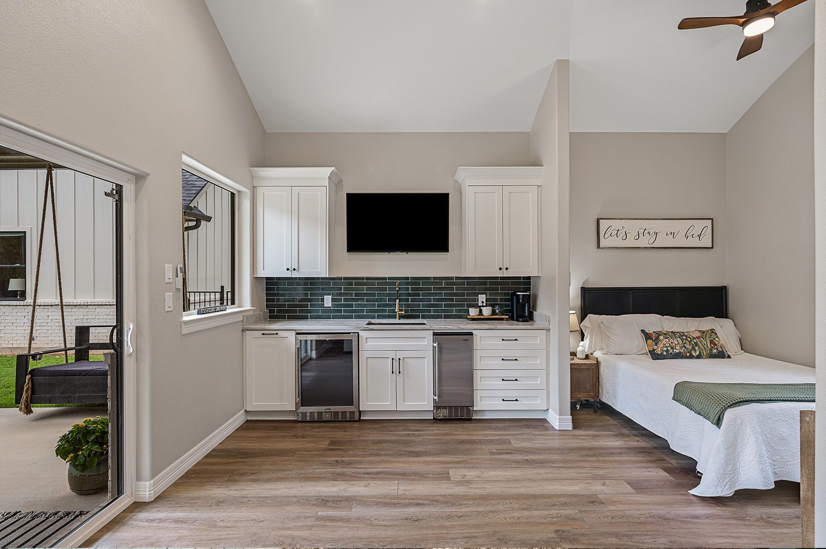 A bedroom with a bed , kitchen , and television.