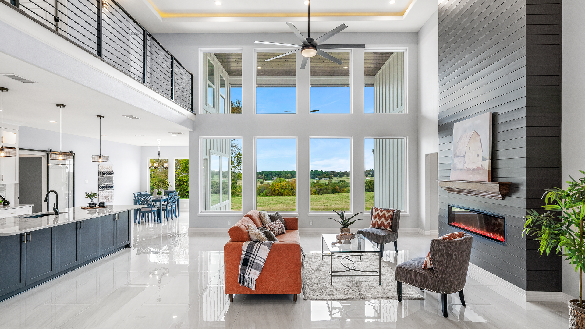 A living room with a couch , chairs , a fireplace and a ceiling fan.