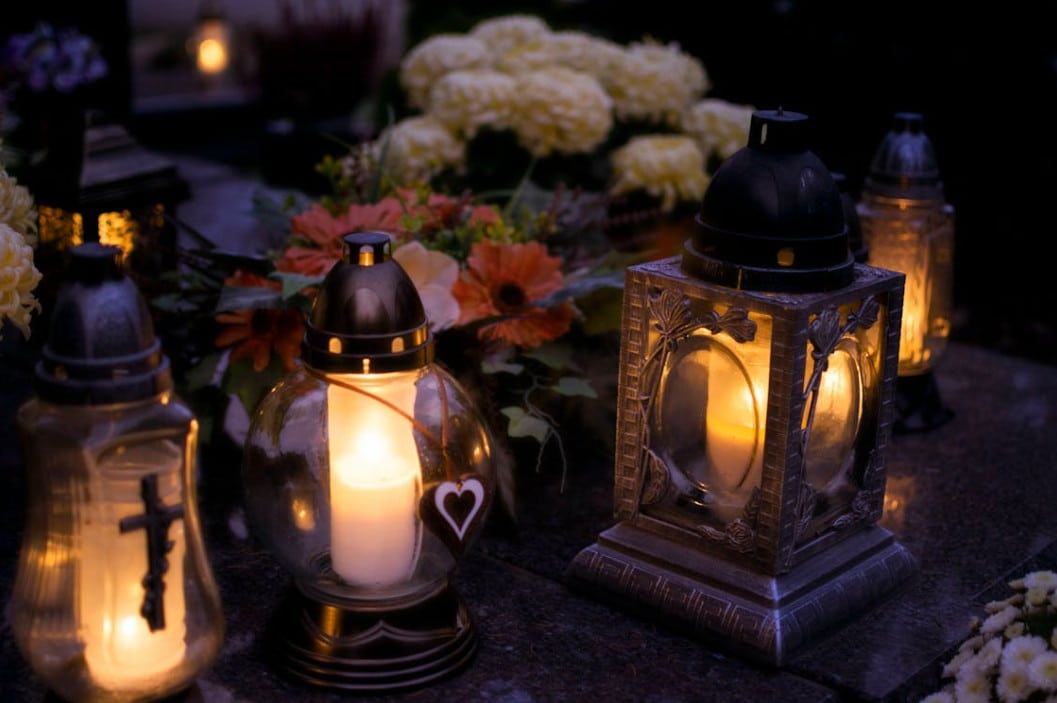 Memorial candles and flowers at a gravesite reflecting funeral and cremation services remembrance
