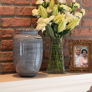 a group of urns sitting on top of a wooden table .