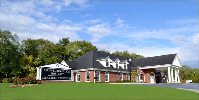 a brick building with a black awning that says funeral home