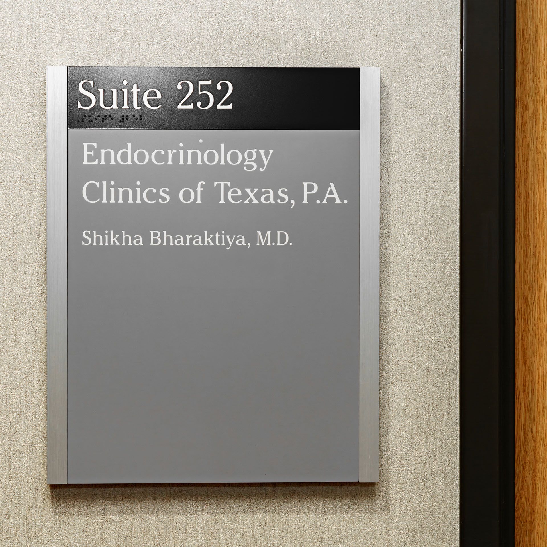Suite 252 sign for Endocrinology Clinics of Texas, P.A., with Shikha Bharatiya, M.D. on a beige wall