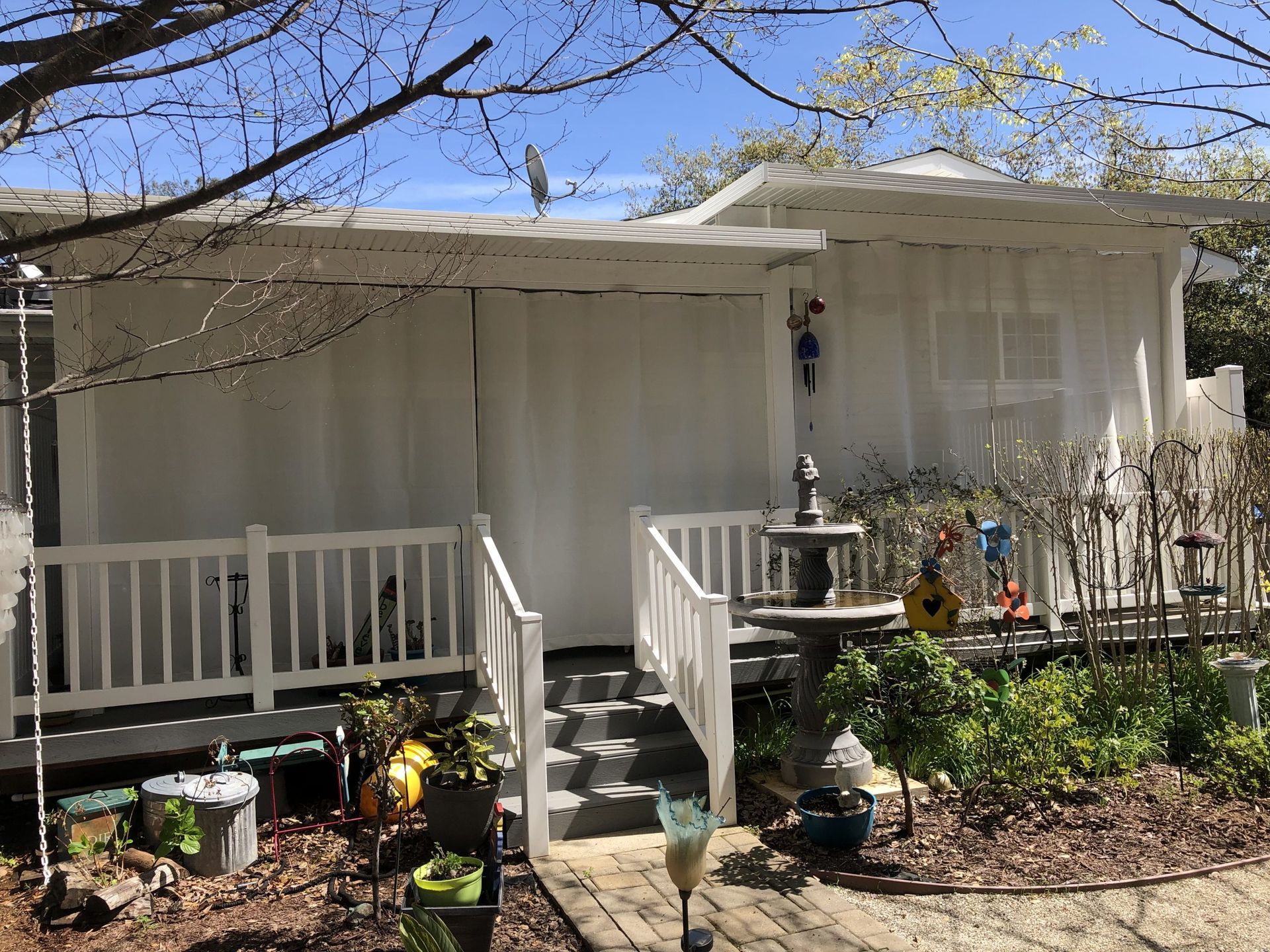 A white house with a white porch and stairs