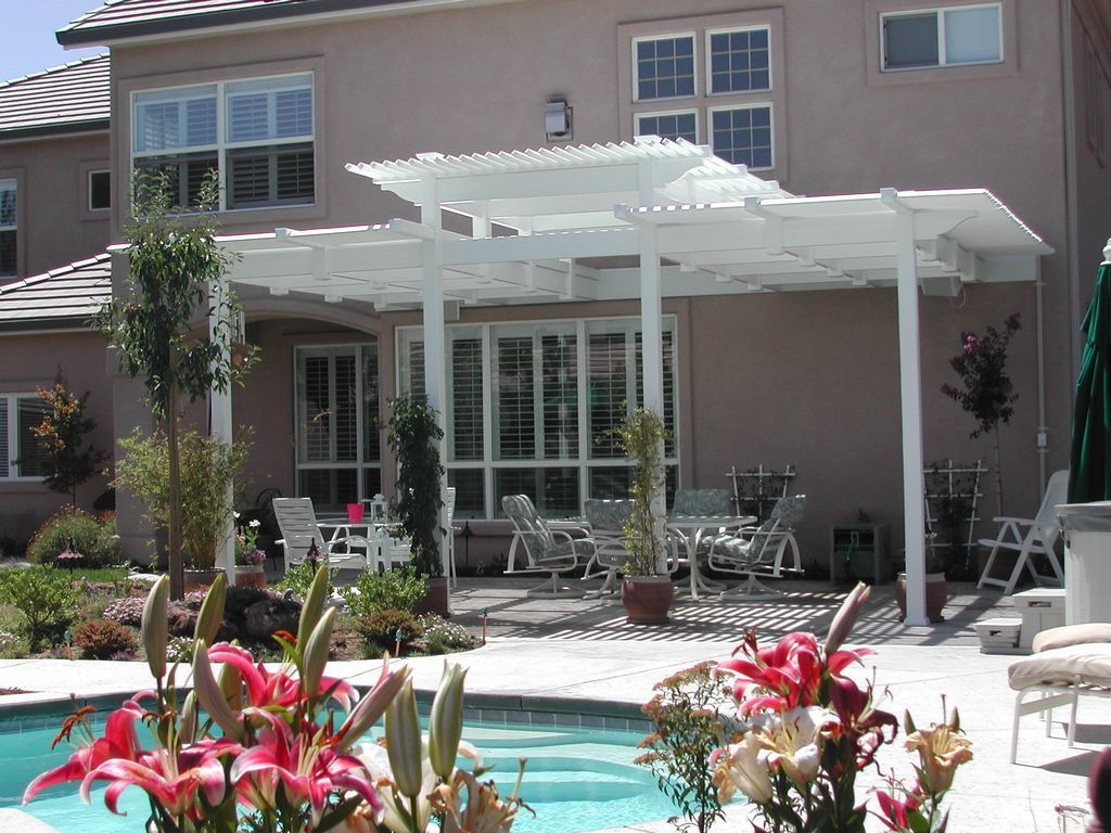 A large house with a pergola over a swimming pool