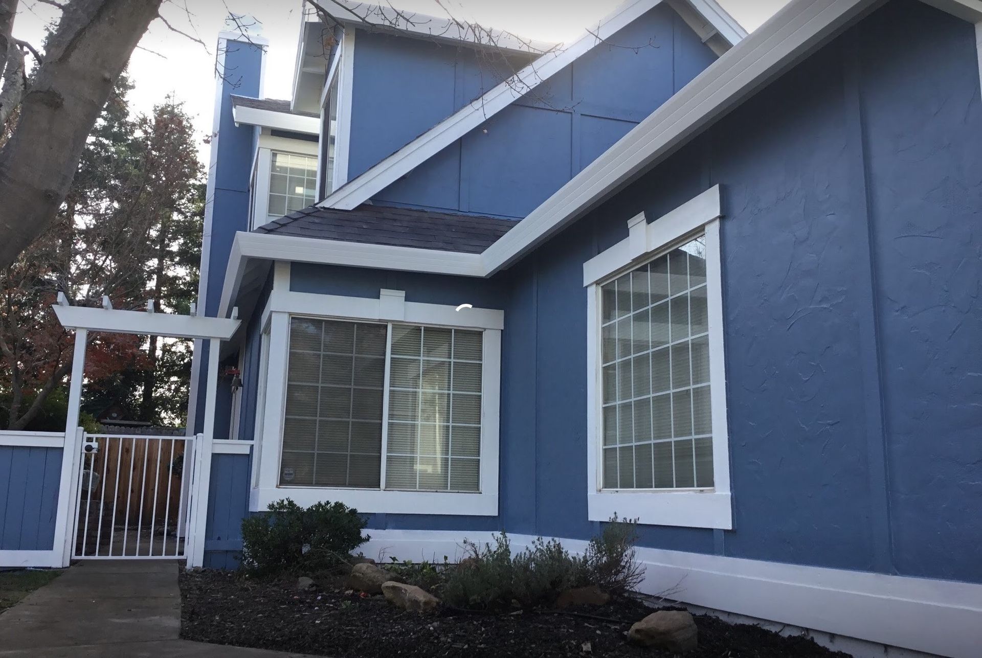 A blue house with white trim and windows