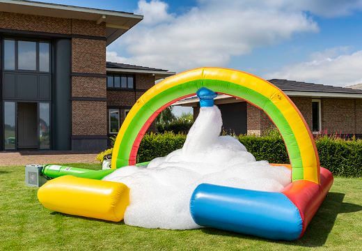 Opstelling voor een schuimparty in de tuin; een regenboogboog over een witte hoop schuim.