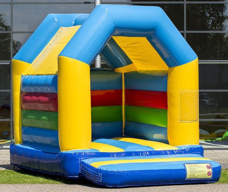 Kleurrijk opblaasbaar springkussen, blauw en geel met regenboogkleurige zijkanten, voor buiten.
