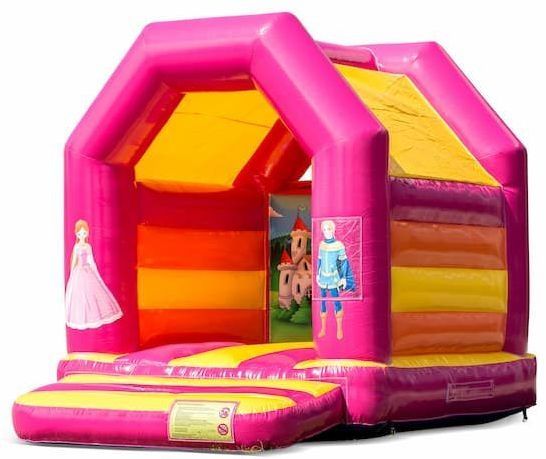 Roze en gele opblaasbare kasteel met afbeeldingen van een prinses en een prins.
