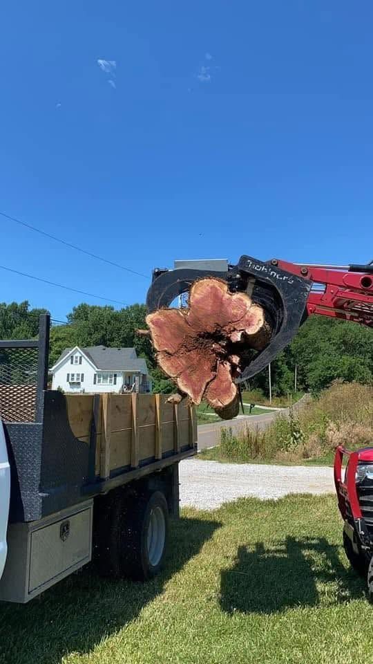Truck-mounted auger drilling a large hole in a lawn near a house under a clear blue sky