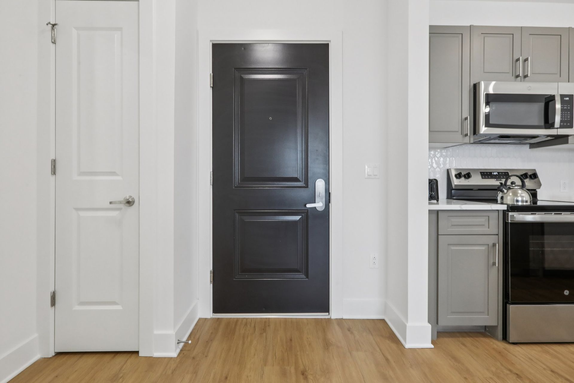 Apartment entry door with keyless access and kitchen view at Meridia Little Ferry NJ