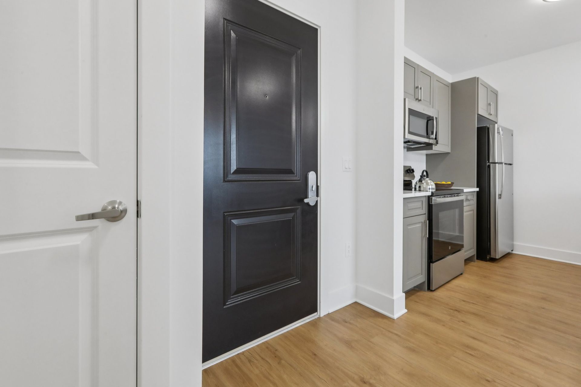 Apartment front door with stainless steel kitchen visible at Meridia Little Ferry NJ