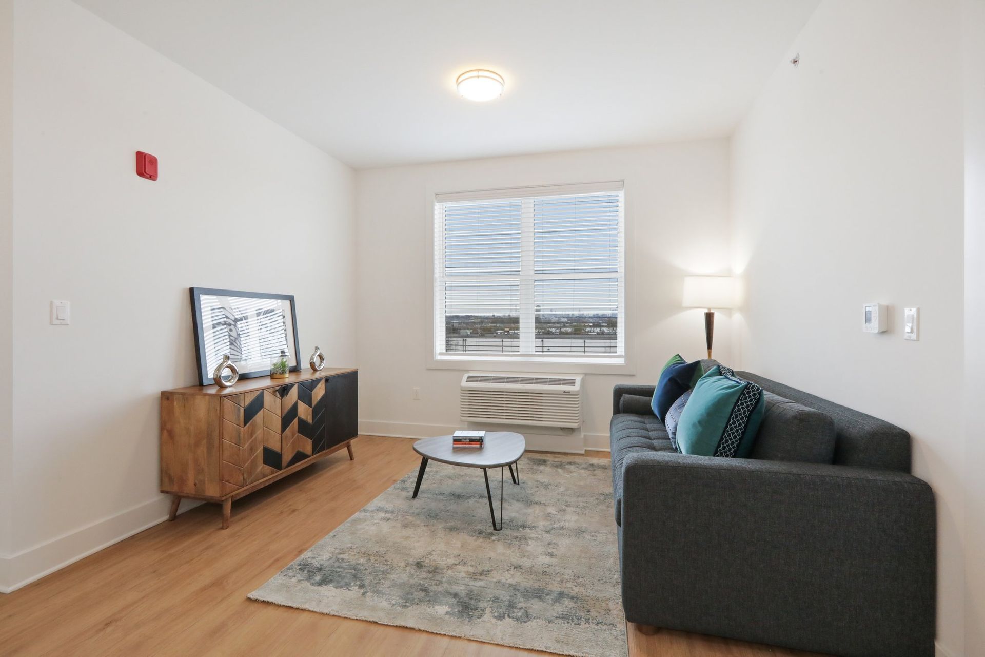Cozy living room with teal accent pillows at Meridia Little Ferry apartments NJ